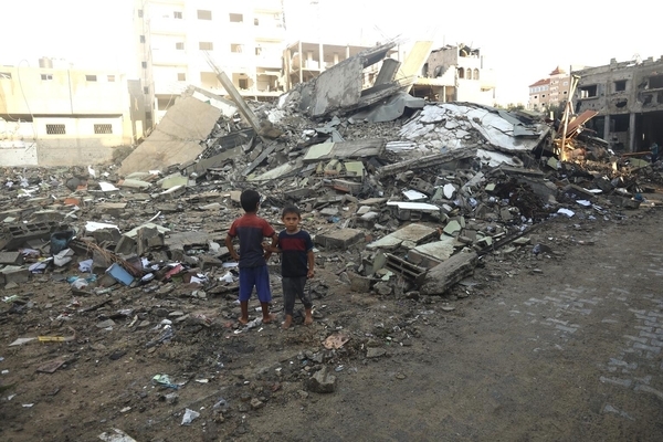 南部のラファで、空爆により破壊された自宅の前に立つ子どもたち。(ガザ地区、2023年10月19日撮影)