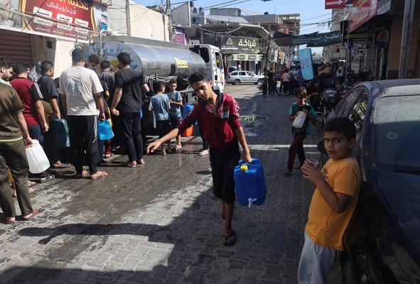 南部のラファで、給水車から水を汲んで運ぶ子どもたち。(ガザ地区、2023年10月17日撮影)