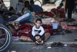 避難所でマットレスの上に座る5歳のアフマドちゃん。何百万人もの人が、この避難所に逃れてきている。(ガザ地区、2023年11月2日撮影)