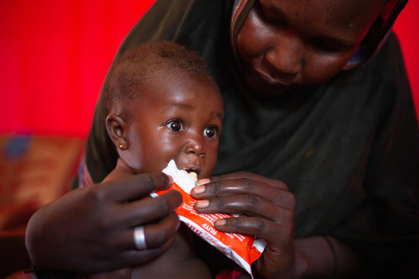 ジャジーラ州の国内避難民キャンプで実施したユニセフが支援する保健キャンペーンで、すぐに食べられる栄養治療食(RUTF)を口にする栄養不良の子ども。(スーダン、2023年10月18日撮影)