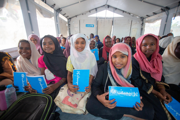 ジャジーラ州のユニセフが設置した安全な学習空間で、ノートや鉛筆、スクールバッグなどの支援物資を受け取り、授業に参加する国内避難民の子どもたち。(スーダン、2023年10月7日撮影)