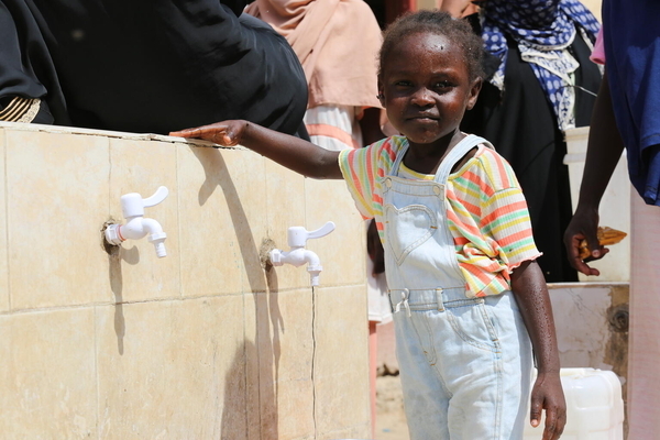 ポートスーダンの国内避難民キャンプで、ユニセフの支援で設置された水道から安全な水を汲む4歳のラワンちゃん。(スーダン、2023年10月17日撮影)