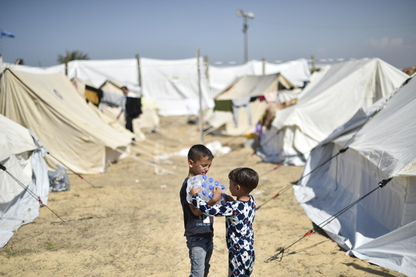 避難民キャンプに届いたユニセフのペットボトルの水を受け取った7歳のヤーマンくんと、4歳のヤーザンくん兄弟。(ガザ地区、2023年11月16日撮影)