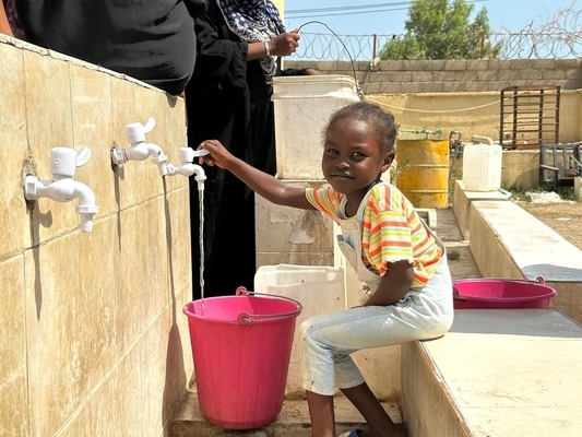 ユニセフの支援で設置された水道から、きれいな水を汲む4歳のラワンちゃん。(スーダン、2023年10月17日撮影)
