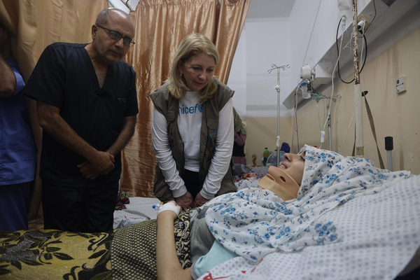 入院している患者と話すラッセル事務局長。(ガザ地区、2023年11月14日撮影)