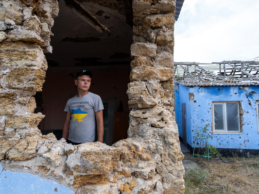 ドネツク州にある通っていた学校が破壊され、大きな穴の開いた校舎の中に立つ15歳のサシュコさん。(ウクライナ、2023年7月撮影)