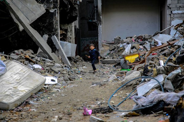 爆撃により破壊された自宅の前を走る5歳のモハメドちゃん。(ガザ地区、2023年12月7日撮影)