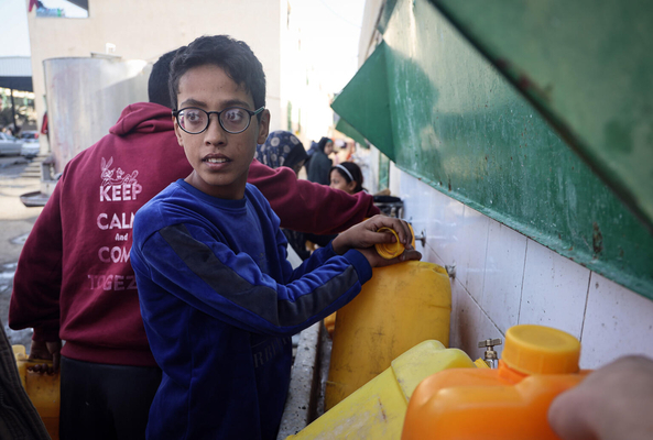 ラファの避難所にある水道から、タンクに水を汲む男の子。(ガザ地区、2023年12月6日撮影)
