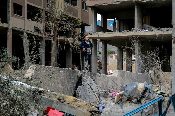 爆撃により破壊された自宅の前に立つ子ども。(ガザ地区、2023年12月7日撮影)