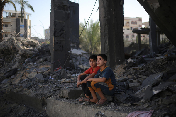 南部のラファで、破壊された自宅のがれきの上に座る子どもたち。(ガザ地区、2023年11月26日撮影)