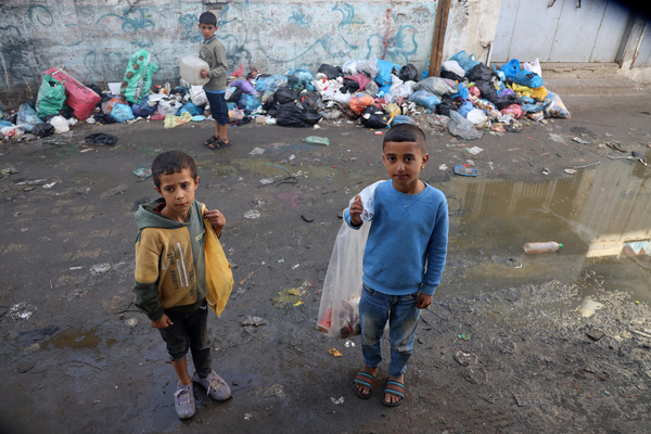 ラファの避難所で、調理の火に使うための段ボールを、路上のゴミの中から探す子どもたち。(ガザ地区、2023年12月6日撮影)