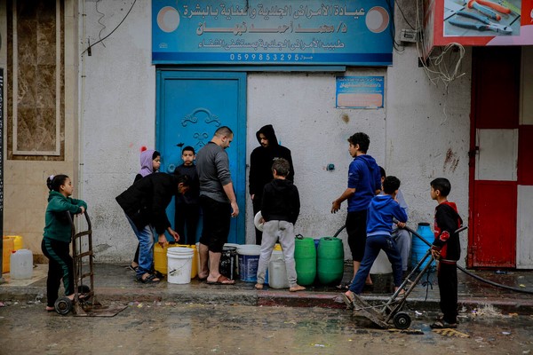 北部のジャバリアで、自宅で使うための水を汲んでいる住民たち。激化する戦闘により安全な水が不足している。(ガザ地区、2023年12月7日撮影)