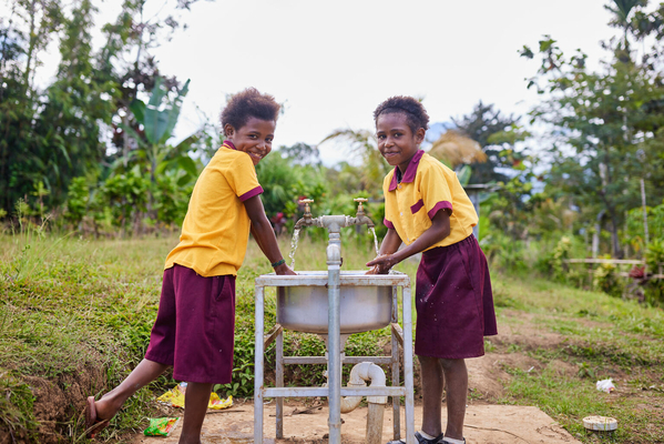 モロベ州の遠隔地の小学校にあるユニセフが支援した手洗い場で、手を洗う9歳のヘイリーさんと、8歳のパトリシアさん。(パプアニューギニア、2023年9月撮影)