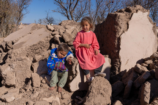ヘラートで、地震により倒壊した自宅のがれきの上に座る子どもたち。(アフガニスタン、2023年12月3日撮影)