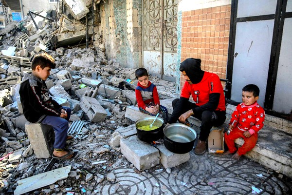 破壊された自宅前で、焚火で料理を作る家族。(ガザ地区、2024年1月11日撮影)
