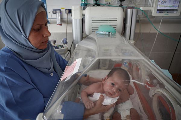 南部のラファにあるエミラティ産科病院で、保育器の中にいる新生児の状態を確認する看護師。(ガザ地区、2024年1月12日撮影)