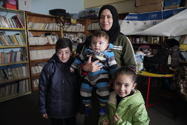 避難所となっているラファ女性センターで、ユニセフ支援の冬服を受け取った家族。(ガザ地区、2024年1月13日撮影)