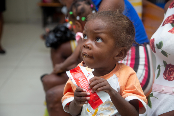 ポルトープランスの保健・栄養センターで、すぐに食べられる栄養治療食(RUTF)を口にする栄養不良の子ども。(ハイチ、2023年6月撮影)
