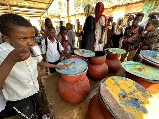中央ダルフール州で、水がめに溜めた水を飲む男の子。(スーダン、2024年2月5日撮影)