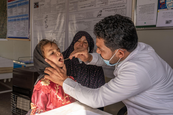 ユニセフが支援する保健所で、呼吸器感染症の診察を受ける8歳のアディナさん。地震により被災した家族は、ユニセフから現金給付の支援を受けて、食料や暖房・調理のための薪などを購入した。(アフガニスタン、2024年1月撮影)