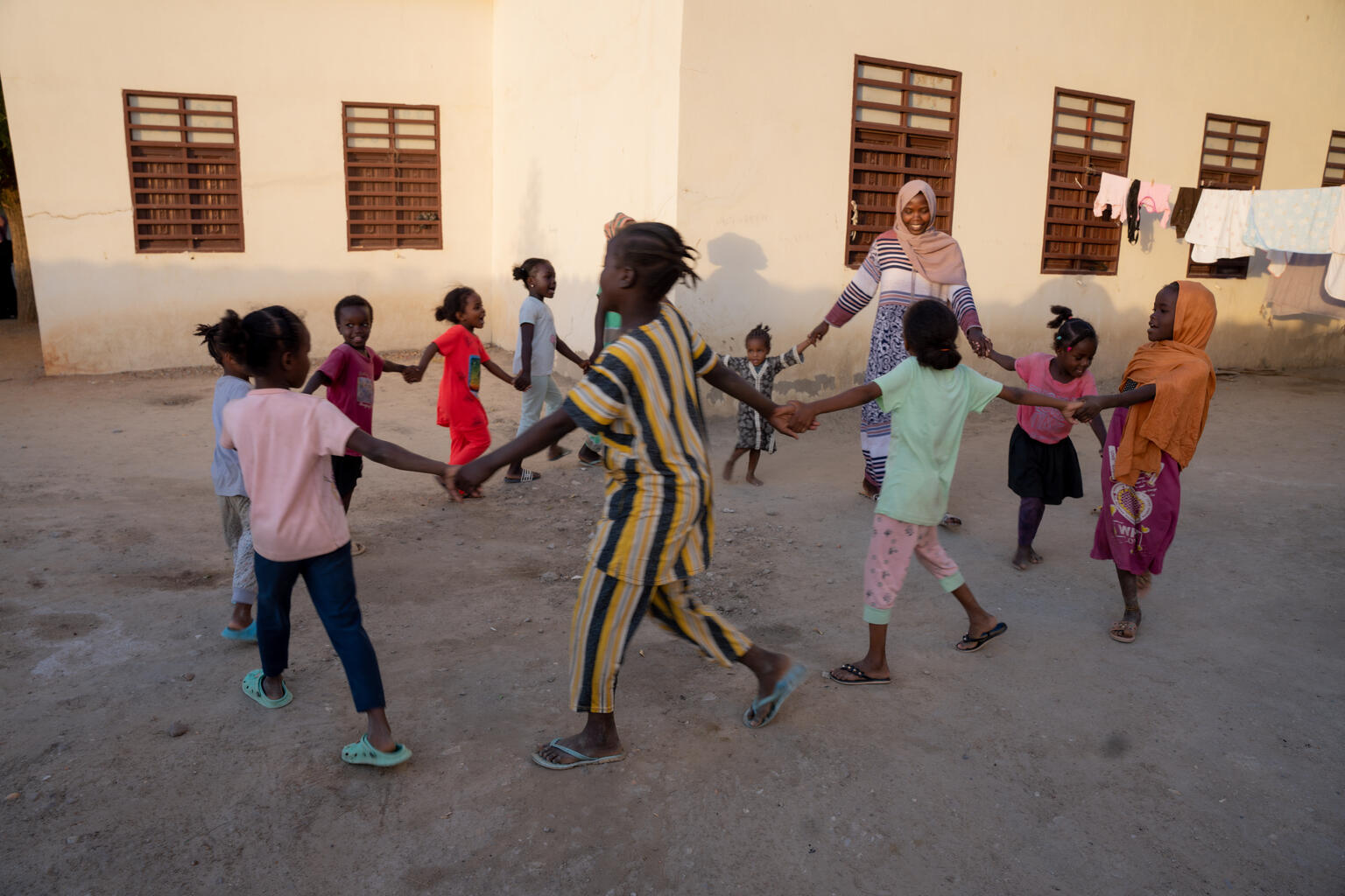 輪になって、サリーマの歌を合唱するハリマさんと子どもたち。(スーダン、2023年11月撮影)