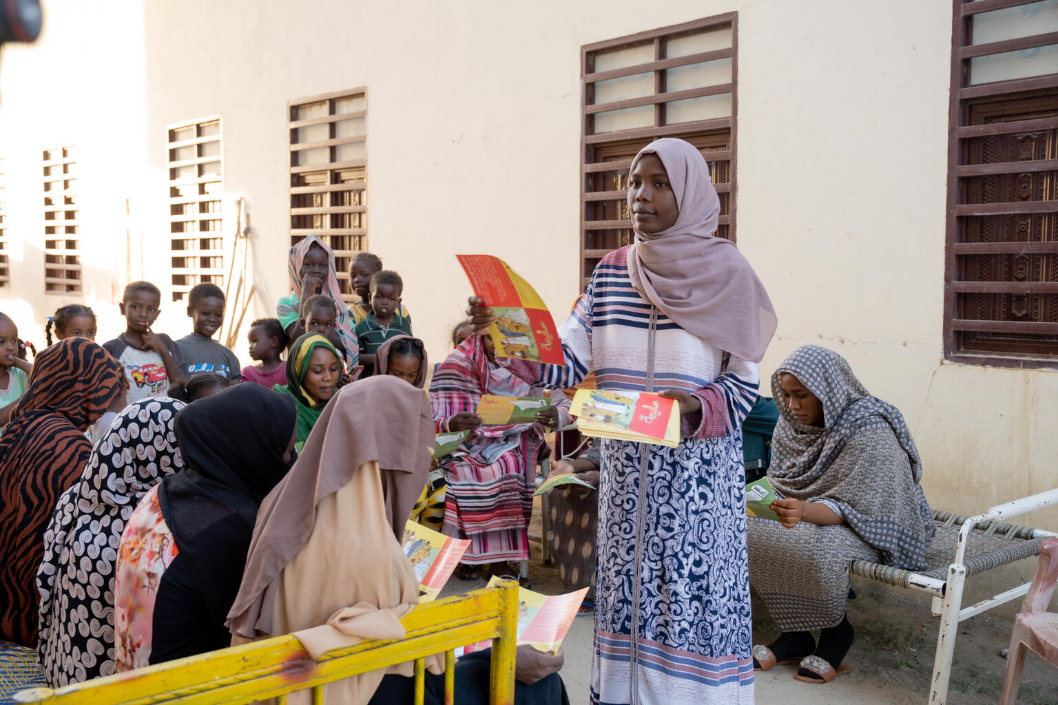 ポスターを使って、コミュニティの人々に有害な慣習について伝えるハリマさん。(スーダン、2023年11月撮影)