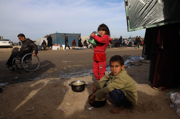 避難所のテントの近くで、家族と食べ物を探す子どもたち。(ガザ地区、2024年1月31日撮影)