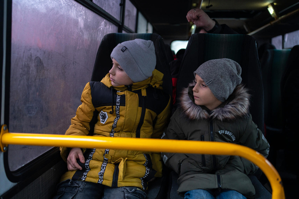 ドネツクから親戚のいるドニプロへ向かうバスに乗る10歳のミキータさんと6歳のセルヒーさん兄弟。避難する前日にユニセフから受け取った冬服を着用している。(ウクライナ、2024年1月撮影)
