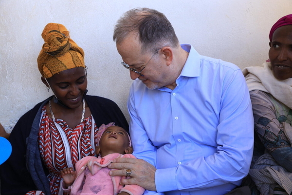 ティグライ州のユニセフが支援する保健センターで、栄養不良の赤ちゃんを見守るユニセフ事務局次長のテッド・チャイバン(中央)。赤ちゃんは重度の栄養不良だったが、治療を受けて回復しつつある。(エチオピア、2024年2月27日撮影)