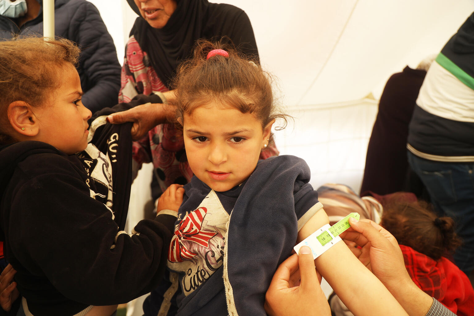 南部ラファにあるユニセフ支援の小児科のテントで、上腕計測メジャーで栄養状態をチェックされている5歳のサマちゃん。(ガザ地区、2024年2月15日撮影)