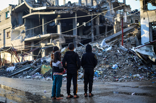 ラファで、爆撃により破壊された建物を眺める子どもたち。(ガザ地区、2024年1月31日撮影)