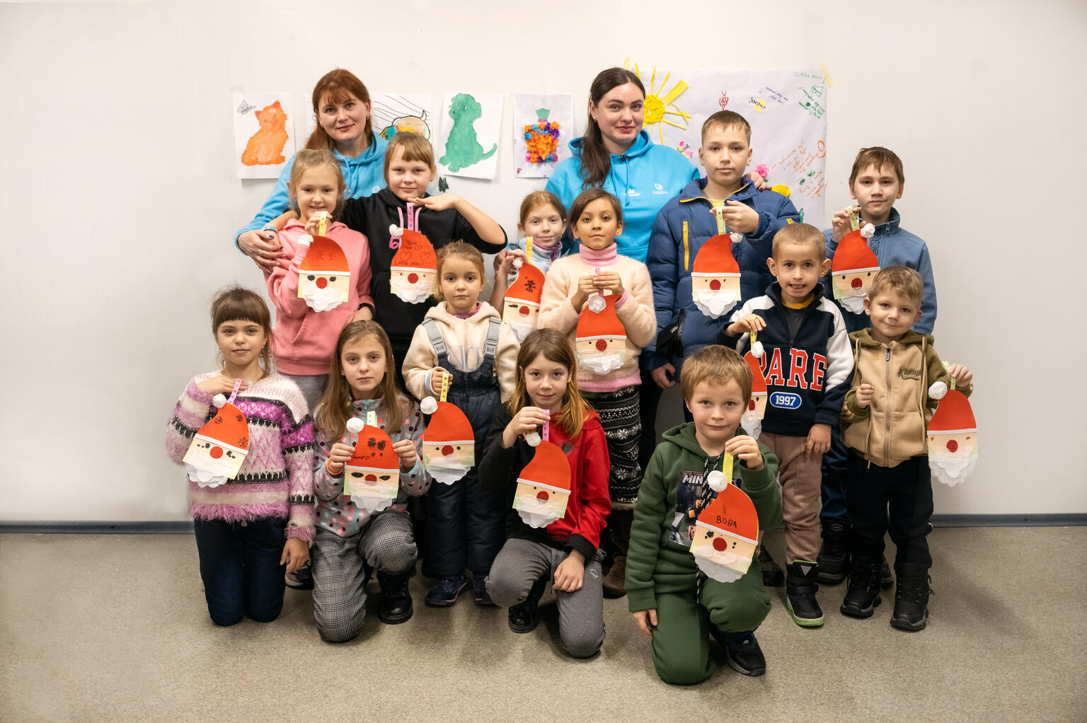 アートセラピーで作成したサンタクロースの飾りを持つ子どもたち（2023年12月14日撮影）