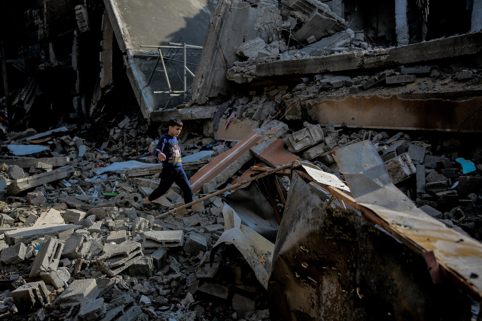 爆撃で破壊された自宅跡を歩く9歳のモハメド。（ガザ地区、2024年1月11日撮影）