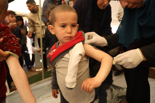 南部ラファにあるユニセフ支援の小児科のテントで、上腕計測メジャーで栄養状態をチェックされている3歳のアクラムちゃん。(ガザ地区、2024年2月15日撮影)