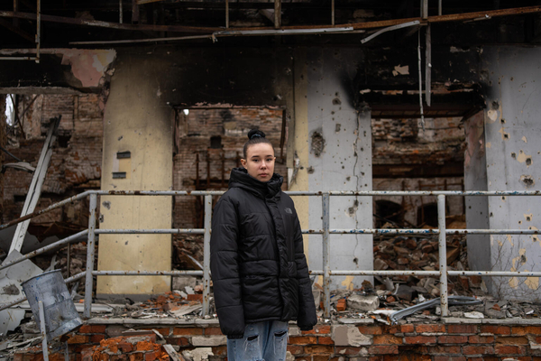 ハルキウのイジュームで、銃弾や砲撃により破壊された建物の前に立つ15歳のナスティアさん。1年前に地雷の爆発に巻き込まれ、手術により30個の破片が身体から取り除かれた。(ウクライナ、2024年3月16日撮影)