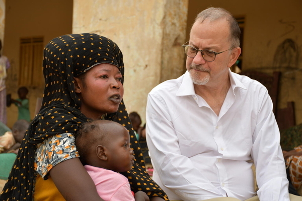 アトバラを訪れ、母親と話すユニセフ事務局次長のテッド・チャイバン。(スーダン、2023年7月撮影)