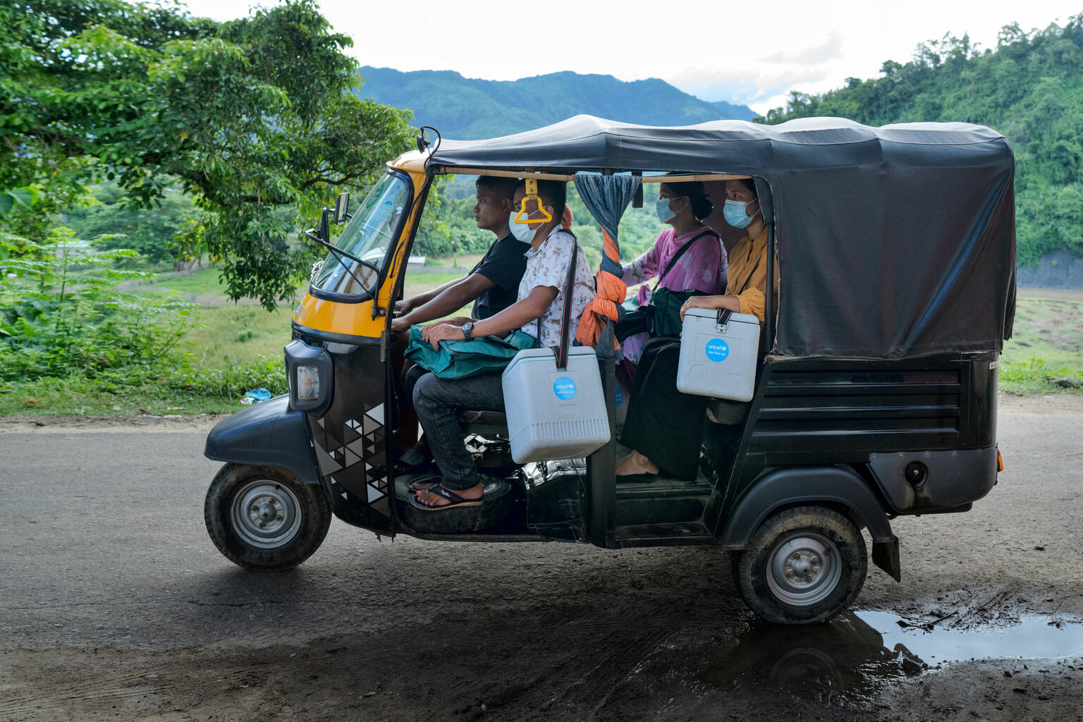 保冷箱に入ったワクチンなどを持ってタクシーに乗り、サング川のほとりに向かう巡回チーム（バングラデシュ、2022年8月21日撮影）