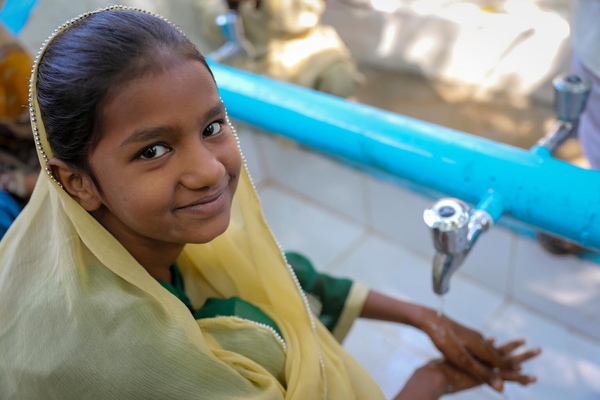 シンド州の小学校で、ユニセフの支援により設置された水道で手を洗う12歳のマハクさん。(パキスタン、2024年11月撮影)