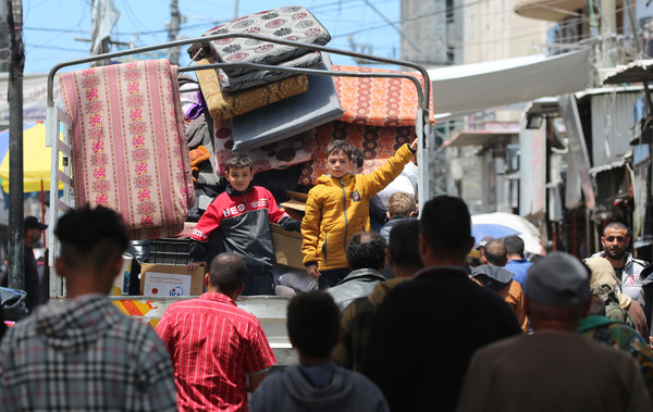 戦闘が激化する南部のラファから、車の荷台に乗って避難する子どもたち。(ガザ地区、2024年5月6日撮影)