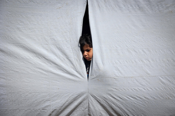 ラファにあるテントの中から外を見る12歳のレムさん。(ガザ地区、2024年5月6日撮影)