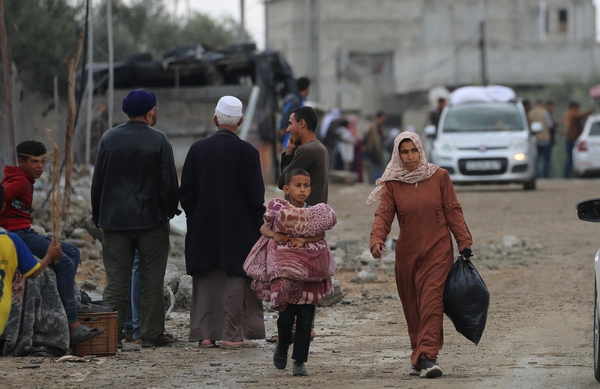 戦闘が激化する南部のラファから、必要最低限の物だけを持って避難する親子。(ガザ地区、2024年5月6日撮影)