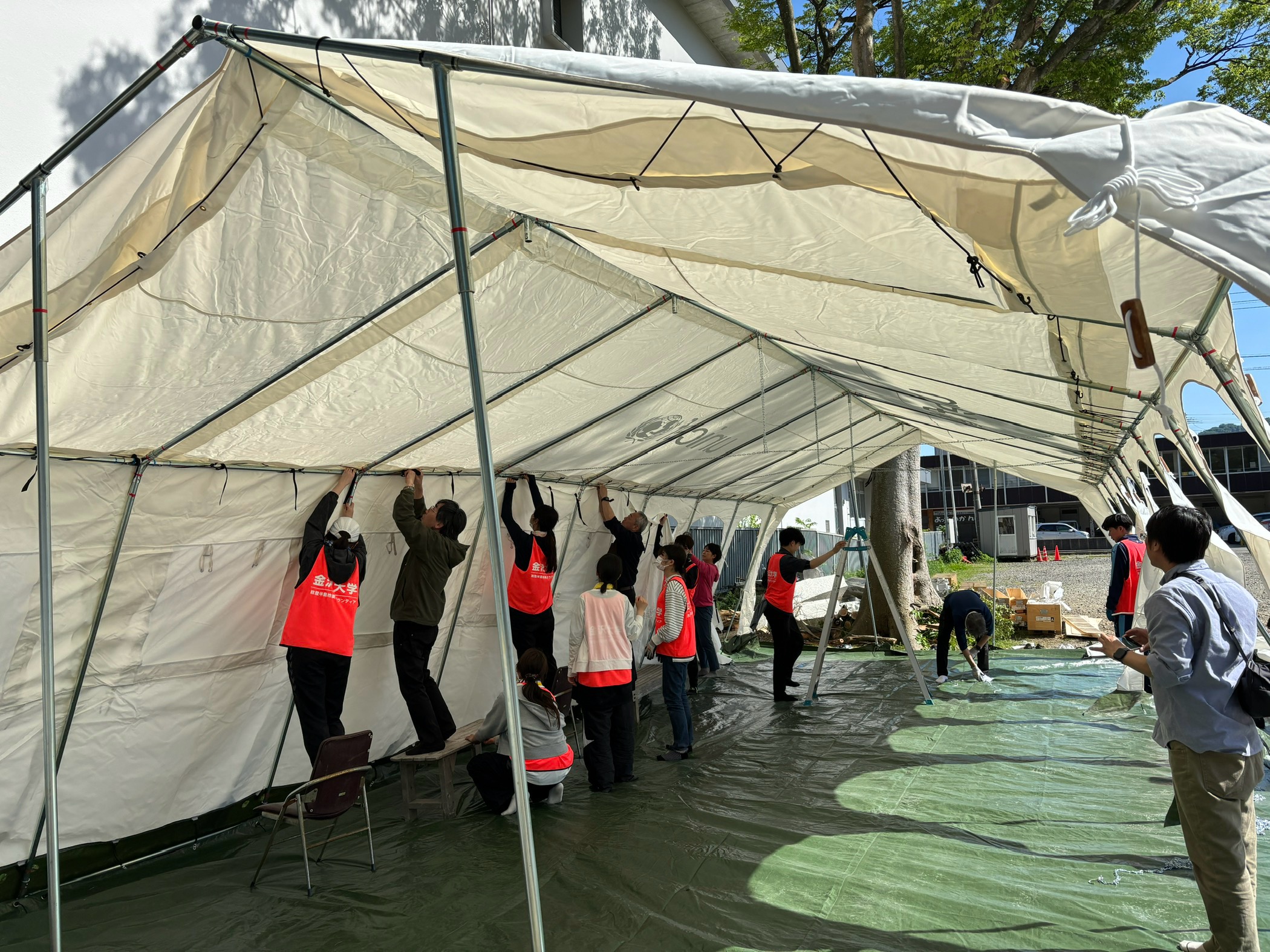 金沢大学学生ボランティアによる、ユニセフの緊急支援用テントの設営。(石川県輪島市重蔵神社、2024年5月11日撮影)