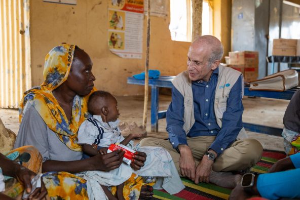 ハルツーム州ジャバラ・アウリアの診療所で、栄養治療を受けている子とその母親と会話するユニセフ・スーダン事務所代表のシェルドン・イェット(スーダン、2025年8月3日撮影)