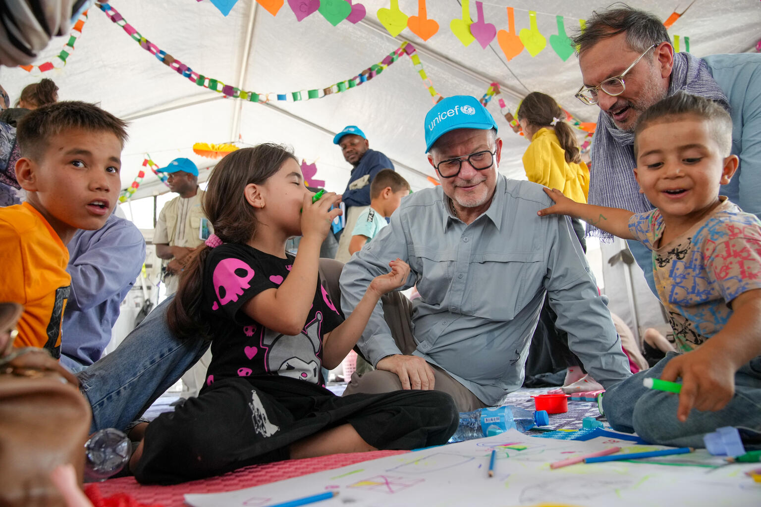 西部ヘラート近郊のイスラムカラ受入センターにユニセフが設置した「子どもにやさしい空間」で、子どもたちと交流するユニセフ事務局次長のテッド・チャイバン(アフガニスタン、2025年8月5日撮影)