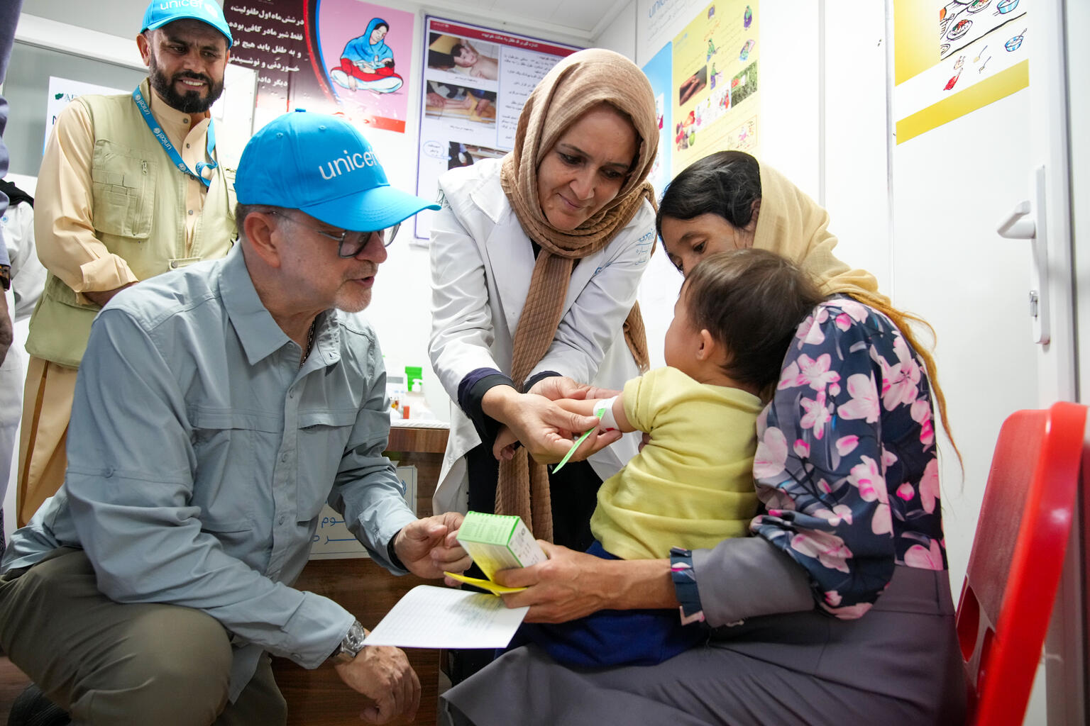 イスラムカラ受入センターで、栄養検査を受ける子どもとその母親に面会するユニセフのチャイバン事務局次長(アフガニスタン、2025年8月5日撮影)