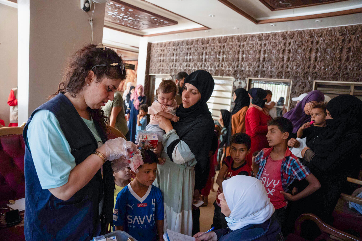 ダマスカス郊外のサイイダ・ザイナブにある避難所で、避難してきた子どもたちの診療をする小児科医。ユニセフ支援の移動式保健・栄養チームに所属している（シリア、2025年7月30日撮影）