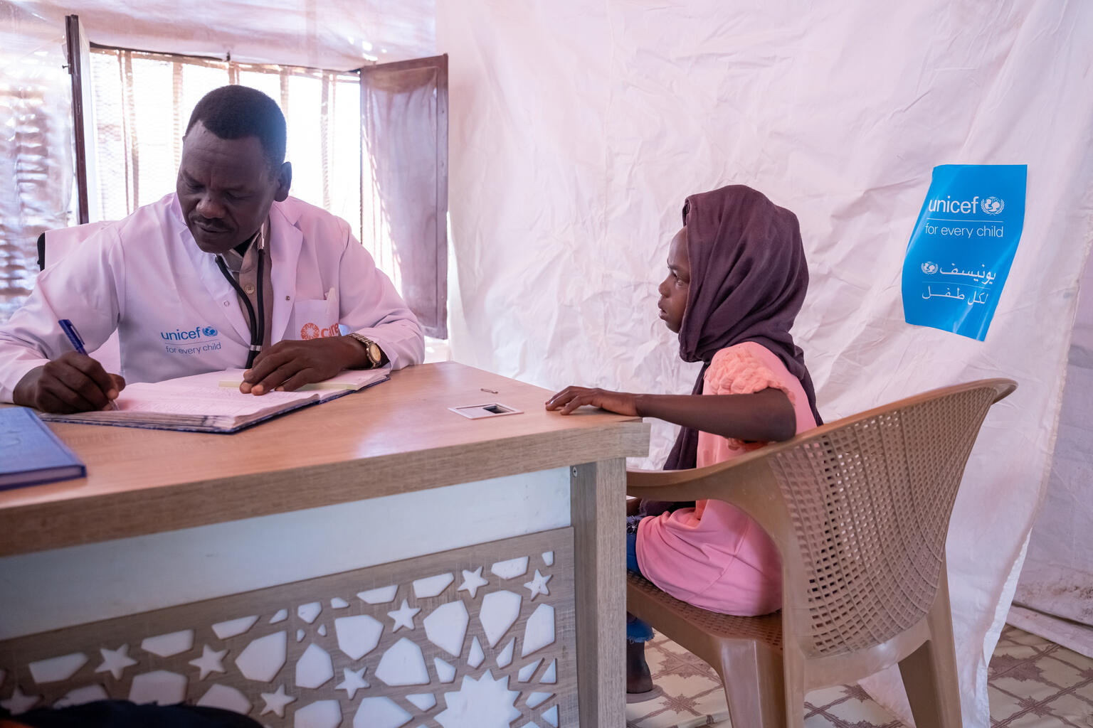 訪れた仮設クリニックで医師に自身の症状を伝えるテンジルさん（スーダン、2025年5月30日撮影）