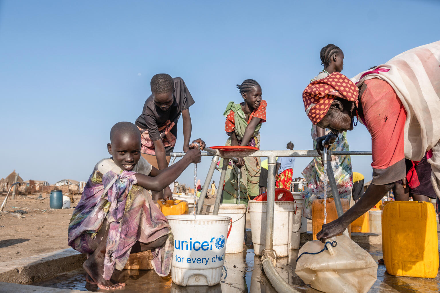 ユニティ州で、新しく設置された給水設備から水をくむ女の子たち(南スーダン、2025年3月14日撮影) © UNICEF/UNI782095/