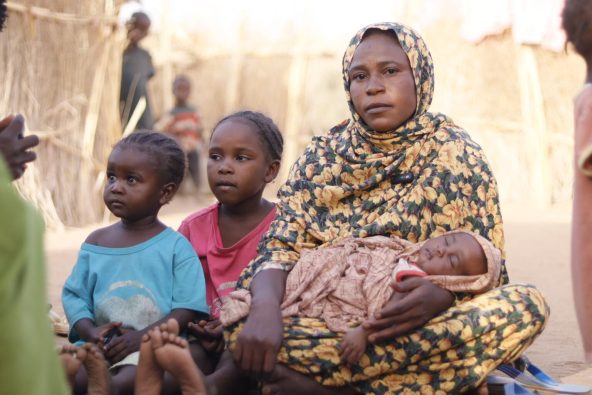 北ダルフール州エル・ファーシルで戦闘が激化し、タウィラの一時避難所まで逃れてきた家族。生まれたばかりの赤ちゃんを抱いている（スーダン、2025年8月23日撮影）