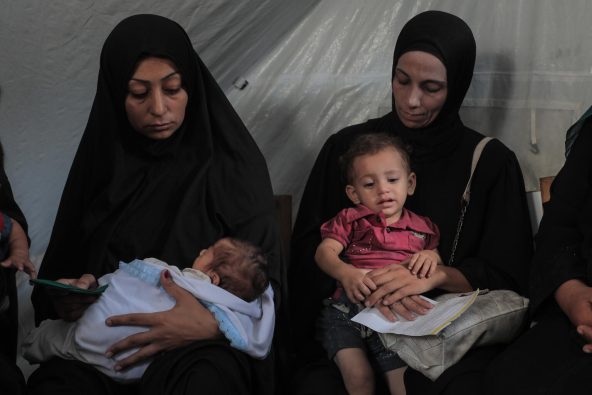 ガザで、ユニセフの支援による栄養検査と栄養治療食の配布を待つ親子（パレスチナ、2025年8月26日撮影）